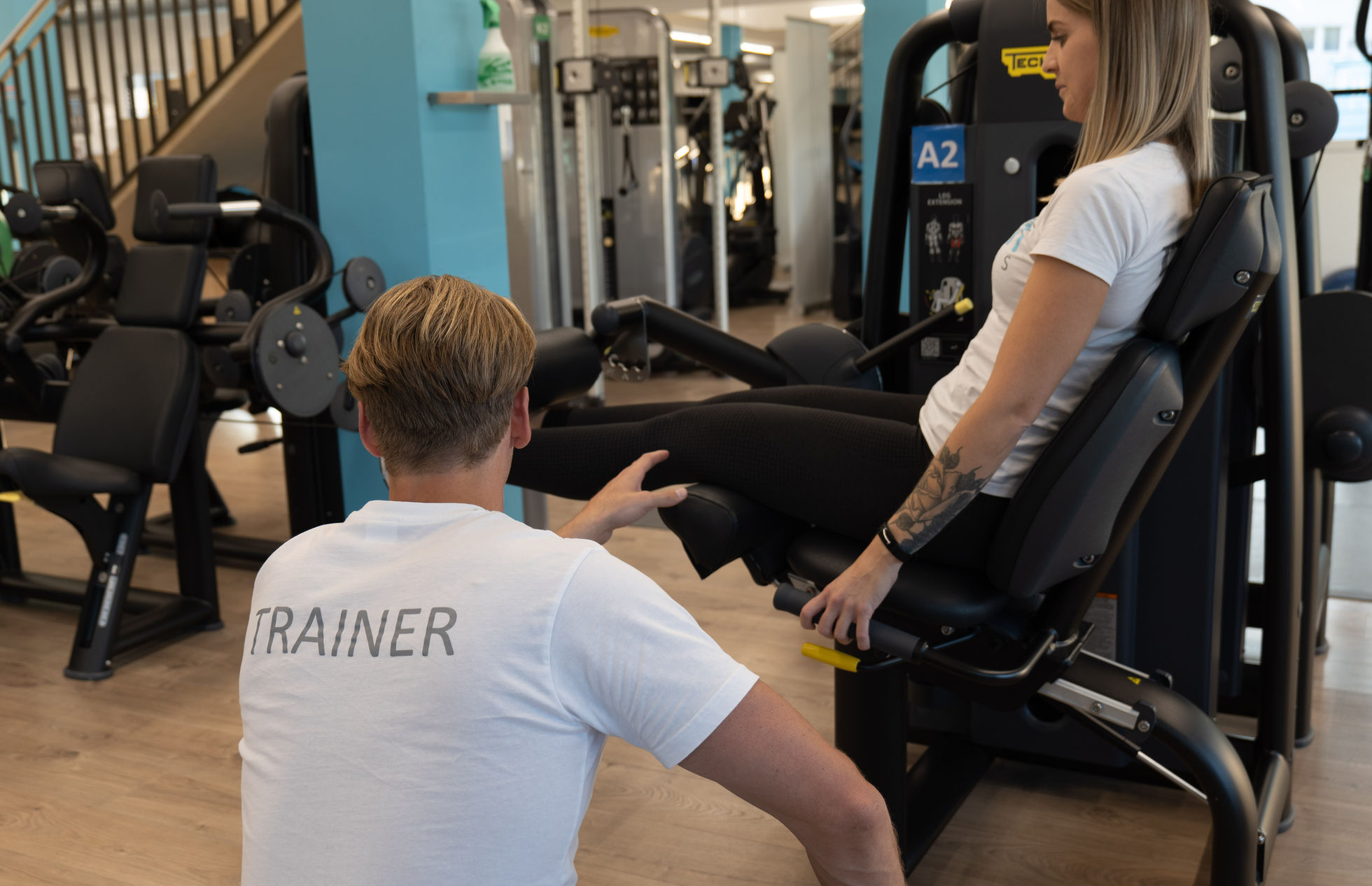 Persönliche Trainingsbetreuung an einem Kraftgerät im INFINITI Fitness