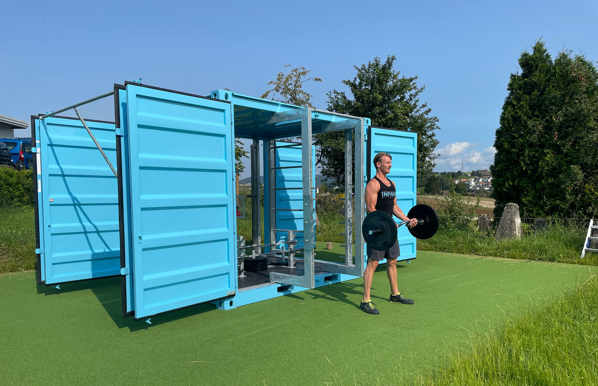 Krafttraining neben dem geöffneten blauen INFINITI Outdoor-Container