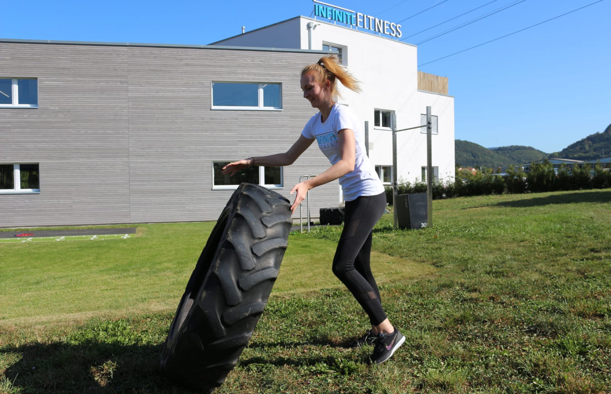 Kraftübung mit einem Traktorreifen auf der INFINITI Outdoor-Fläche