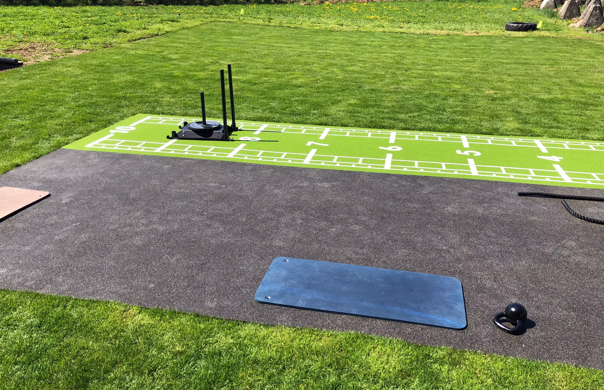 Trainingsmatte und Schlitten neben der markierten INFINITI Outdoor-Bahn