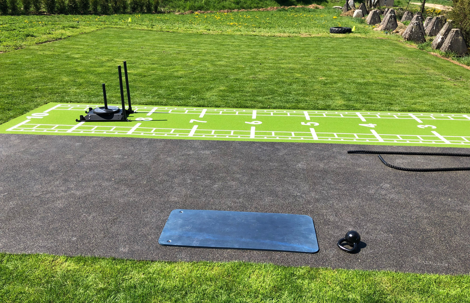 Fitnessschlitten und Trainingsmatte an der Outdoor-Bahn des INFINITI Fitness